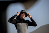 ION Safari Hat PRO 2026 schwarz, Frontalansicht, Wassersport-Hut mit breiter Krempe und Kinnriemen, getragen von Person in Neoprenanzug