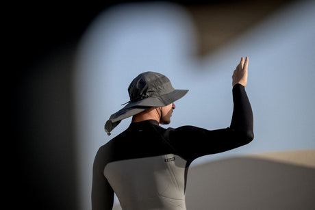ION Safari Hat PRO 2026 schwarz, Seitenansicht auf Person mit Neoprenanzug, funktionaler Sonnenschutz mit Nackenbereich
