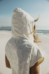 ION Surf Poncho Select Reefside 2024 weiß, Kapuze über Kopf, Strandszene, Rückansicht, Waffeltuch-Material