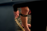 ION Wing Board Leash Core Coiled Knee 2026, gelb-schwarze Spiralschnur, um Bein getragen, Detailaufnahme