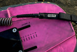 ION Wing Board Leash Core Coiled Knee 2026 schwarze Kabelschlaufe mit Spiralwicklung auf rosa Kiteboard, Draufsicht