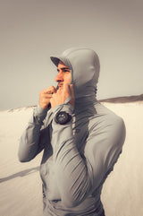 ION Rashguard Sun Pro SS26 grau mit Kapuze, Frontansicht auf Person am Strand