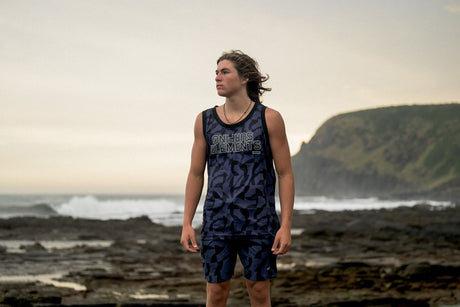 ION Basketball Shirt 2026 dunkelblau mit Muster, Herrenmodell, Frontalansicht am Strand getragen