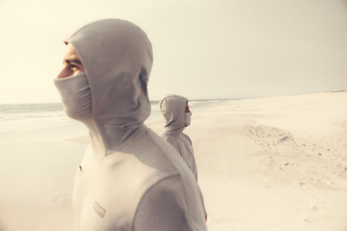ION Storm Pro LS 2026 Funktionsjacke grau-weiß mit Kapuze am Strand, Seitenansicht