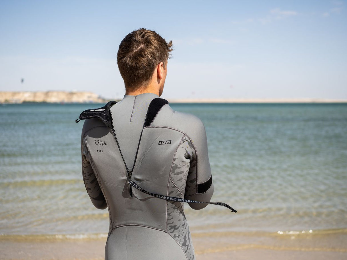 ION Seek Core 4/3 Back Zip Neoprenanzug grau-schwarz, Rückansicht am Strand