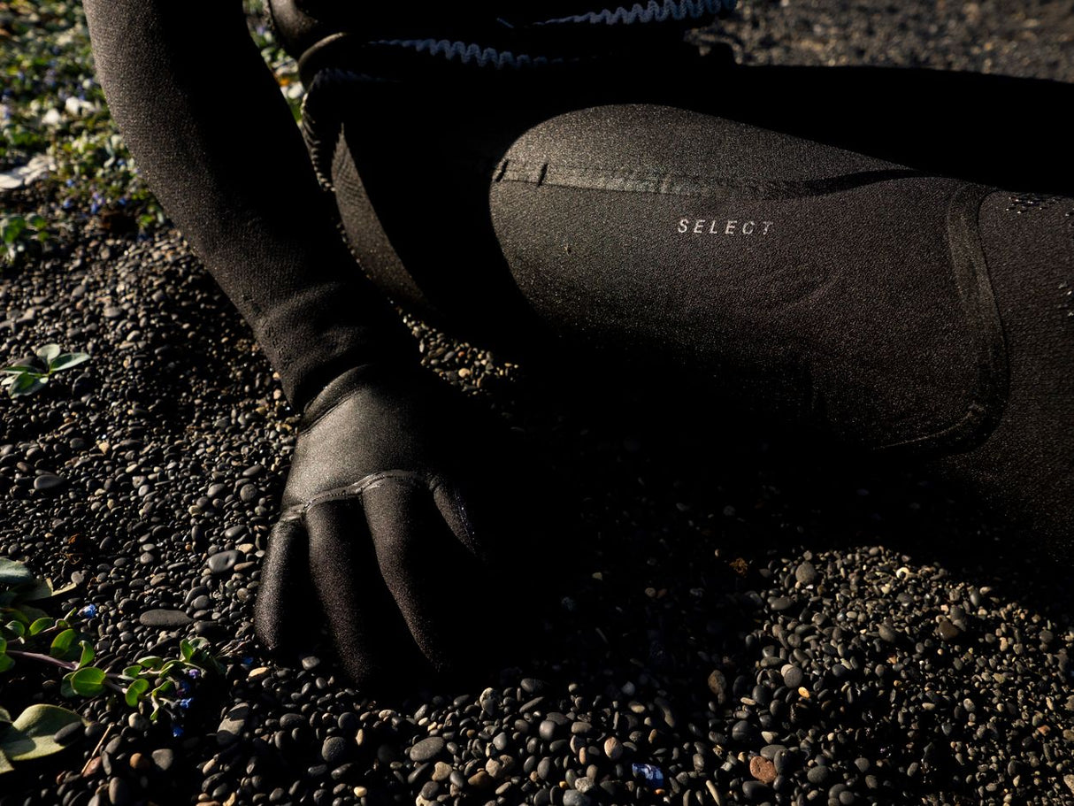 Schwarze Sportleggings mit Select-Branding, getragen mit schwarzem Top, Detailaufnahme beim Outdoor-Training auf Kiesweg