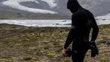 Schwarzer Laufanzug, Seitenansicht, Mann beim Trailrunning in Berglandschaft mit Gletscher
