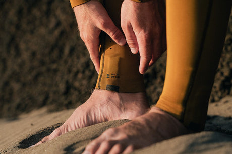 ION Seek Core 3/2 Front Zip Neoprenanzug in Goldgelb, Detail der Knöchelmanschette am Strand