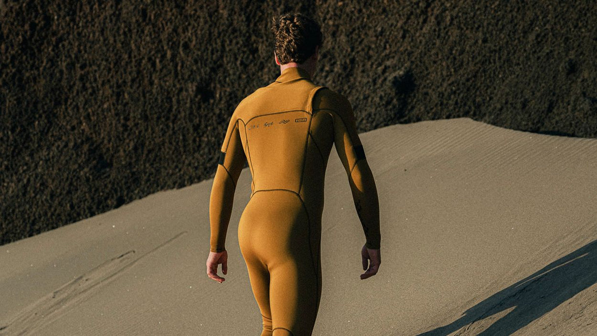 ION Seek Core 3/2 Front Zip Neoprenanzug in Gelb und Schwarz, Rückenansicht, Mann trägt Surfanzug am Strand