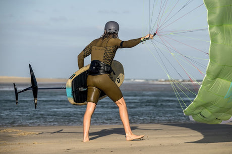 ION Rave 2026 Kite in Grün, Athlet am Strand hält Lenkdrachen, Kitesurfing-Ausrüstung