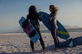 ION Sol Curv 2026 Kiteboard blau, zwei Kitesurfer am Strand mit Board