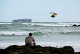 ION Hüftgurt 2026 schwarz, Neopren-Kitegurt, Frontalansicht am Strand mit Kitesurfer