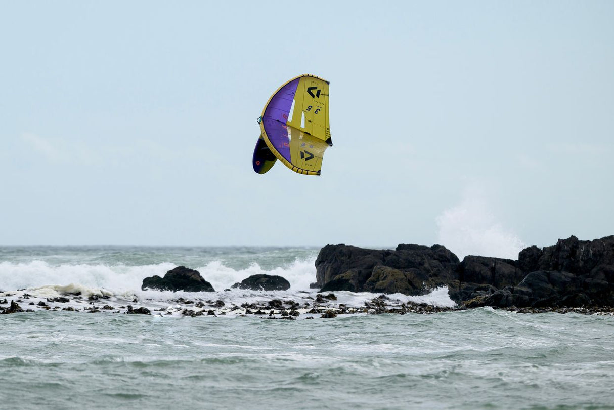 ION Hüftgurt 2026 in Gelb-Lila, aufgeblasen über dem Meer, Frontalansicht beim Kitesurfing