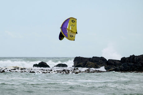 ION Hüftgurt 2026 in Gelb-Lila, aufgeblasen über dem Meer, Frontalansicht beim Kitesurfing
