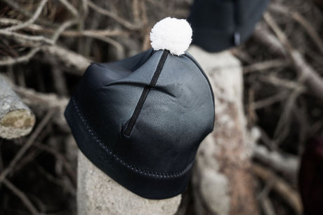 ION Neo Bommel Beanie 2026 in Schwarz mit weißem Bommel, Neopren-Mütze von vorne, Winterbeanie mit Kreuzband-Detail
