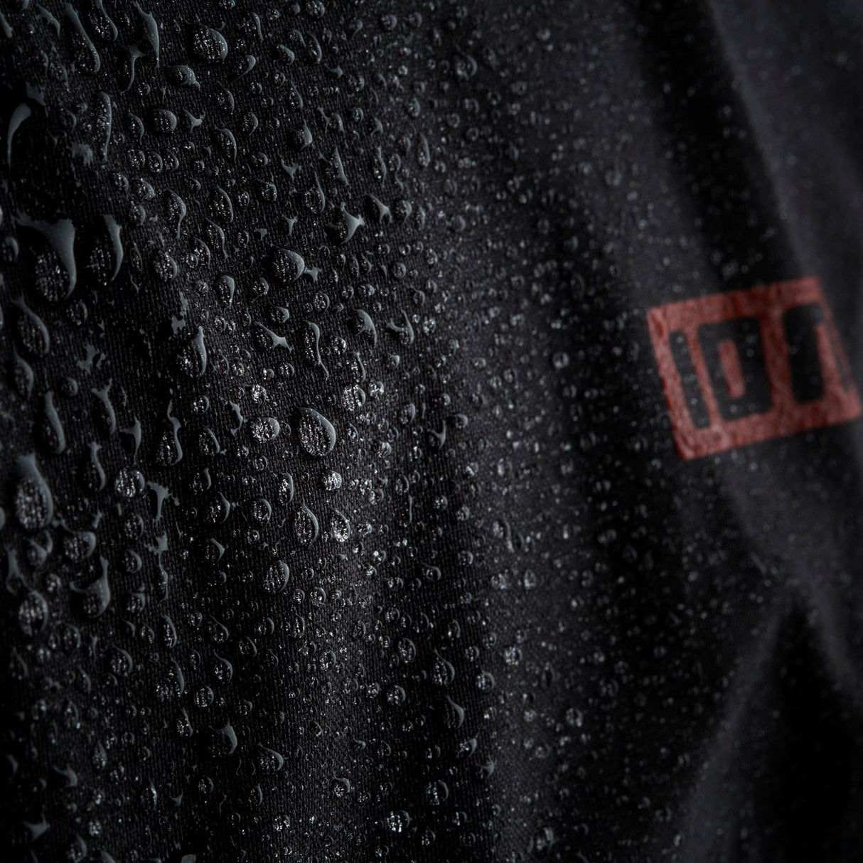 ION Collision Vest Element Side Zip 2026, schwarz, Detailaufnahme wasserabweisendes Material mit ION-Logo