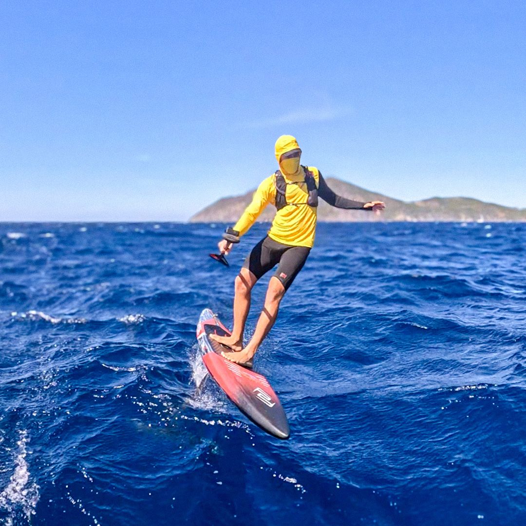 CHASE DW-R Downwind Racing Board, Athlet in gelbem Shirt auf rotem Board auf blauem Meer, Seitenansicht