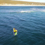 Patrik Wing Gen3 Volant Cross Windsurf-Segel gelb-grün auf Wasser, Draufsicht mit Wellen und Küste im Hintergrund