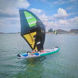 Patrik E-Ride Elektro-Windsurf-Board mit grünem und gelbem Segel auf dem Wasser, Seitenansicht