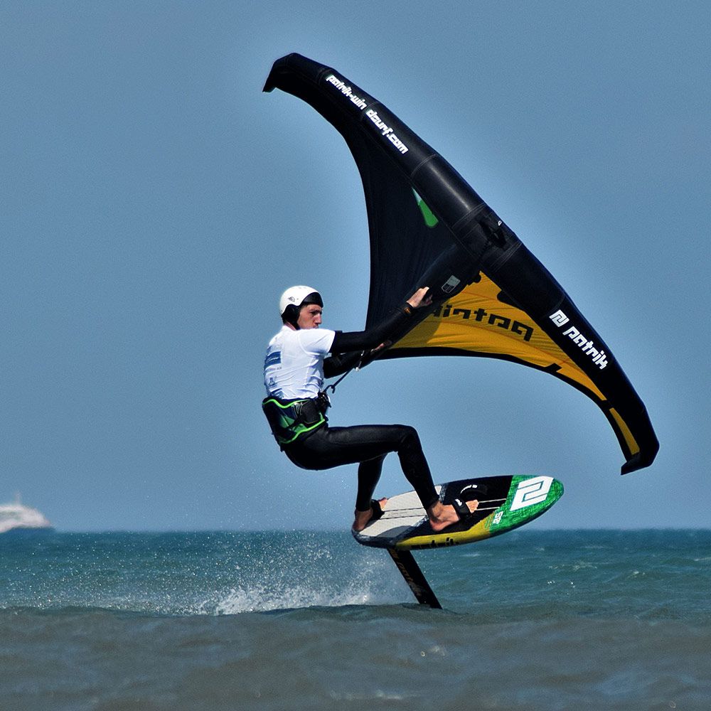 Patrik Wing V2 Volant Cross Kite in Schwarz und Gold, Kitesurfer in Aktion über Wasser