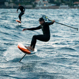 Chase DW-X Downwind SUP orange und schwarz im Einsatz auf Wellen mit Athlet in Neoprenanzug