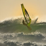 Patrik 4-Wave LTD Windsurfboard in Gelb und Schwarz, in Aktion auf Wellen im Meer