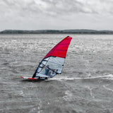 Patrik Race MA Gen2 Windsurfboard mit rotem Segel im Wasser, Seitenansicht