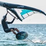 Chase WB-ML Midlength Foilboard in Türkis und Weiß, in Aktion auf dem Wasser mit Fahrer und Segel
