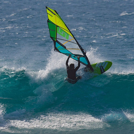 Patrik 4-Wave Windsurfboard in Gelb, Grün und Schwarz, von vorne in Aktion auf dem Wasser mit Windsurfer