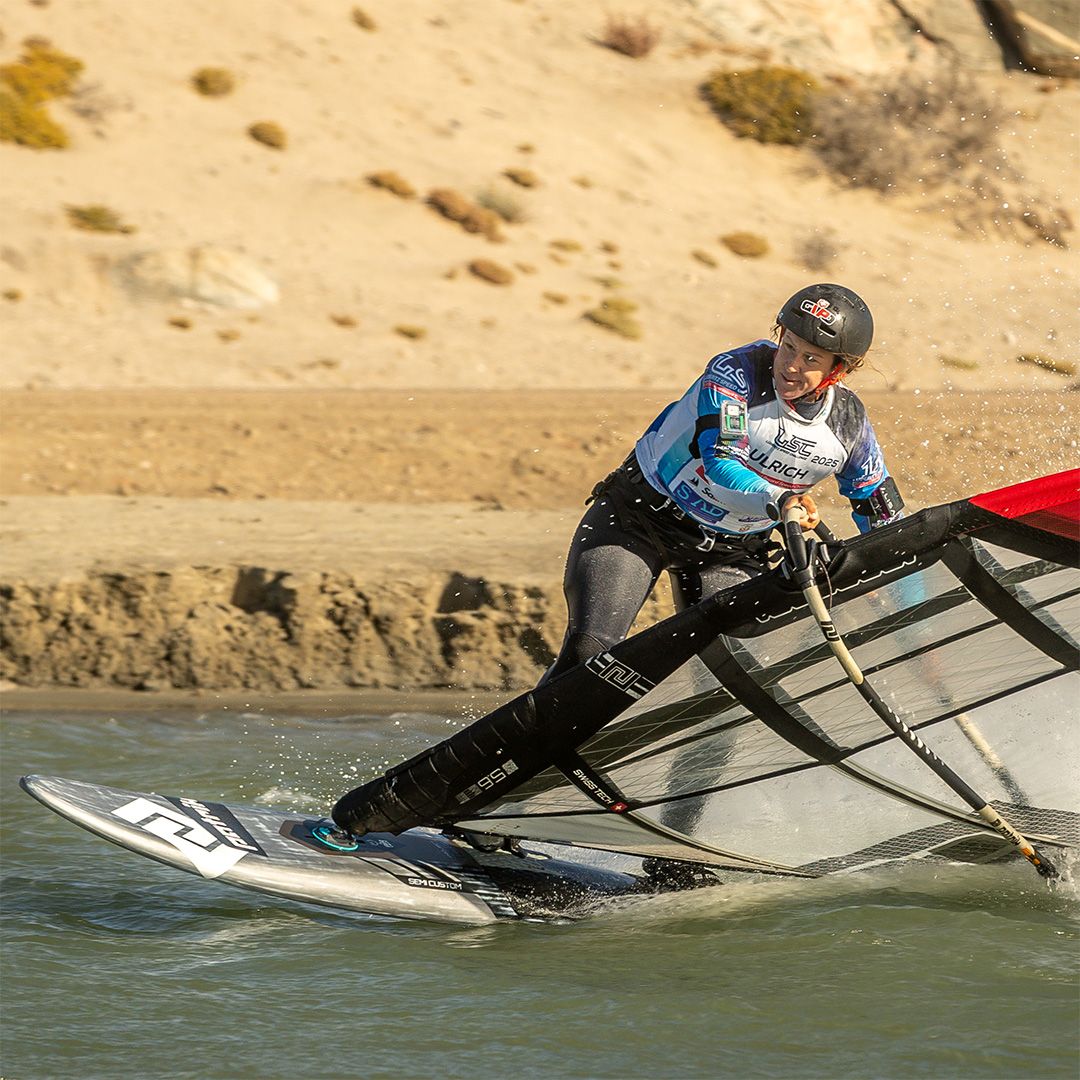 Patrik Speed Windsurfboard in Aktion auf dem Wasser, Fahrer trägt blaues Shirt und schwarzen Helm