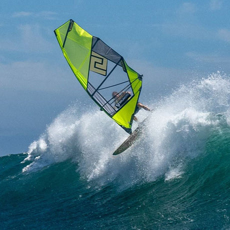 Patrik QTS-Wave Windsurfegel in Neongelb und Grau, in Aktion auf einer Welle, Frontalansicht