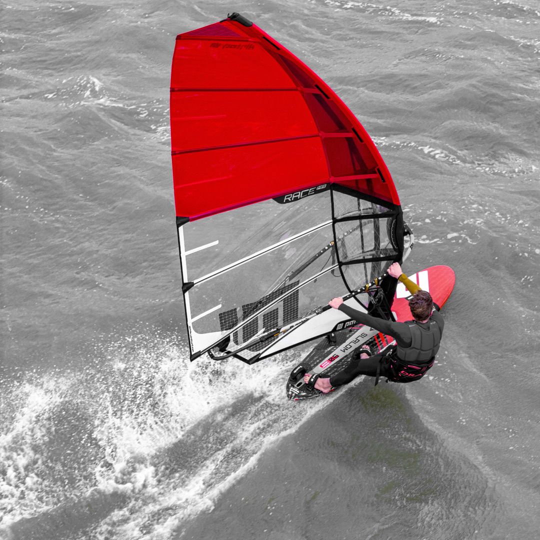 Patrik Race MA Gen2 Windsurfboard mit rotem Segel, Fahrer in Action auf dem Wasser