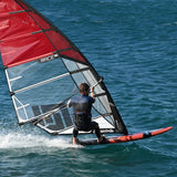 Patrik Slalom Windsurfboard rot-schwarz mit rotem Segel, Athlet in Aktion auf dem Wasser