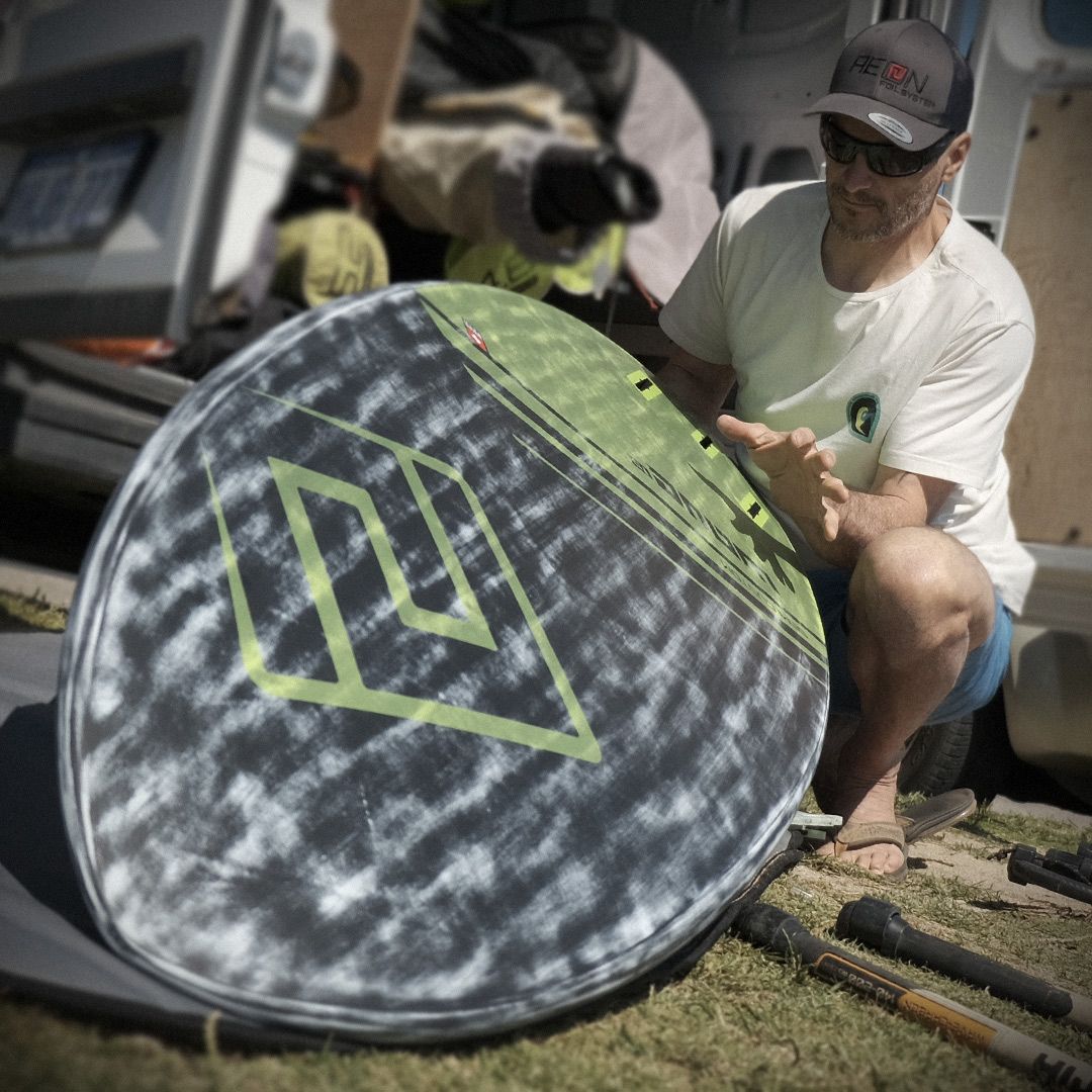 Patrik TS-Wave Wellentasche grau-grün mit Diamant-Muster, Mann hält Board in Nahaufnahme