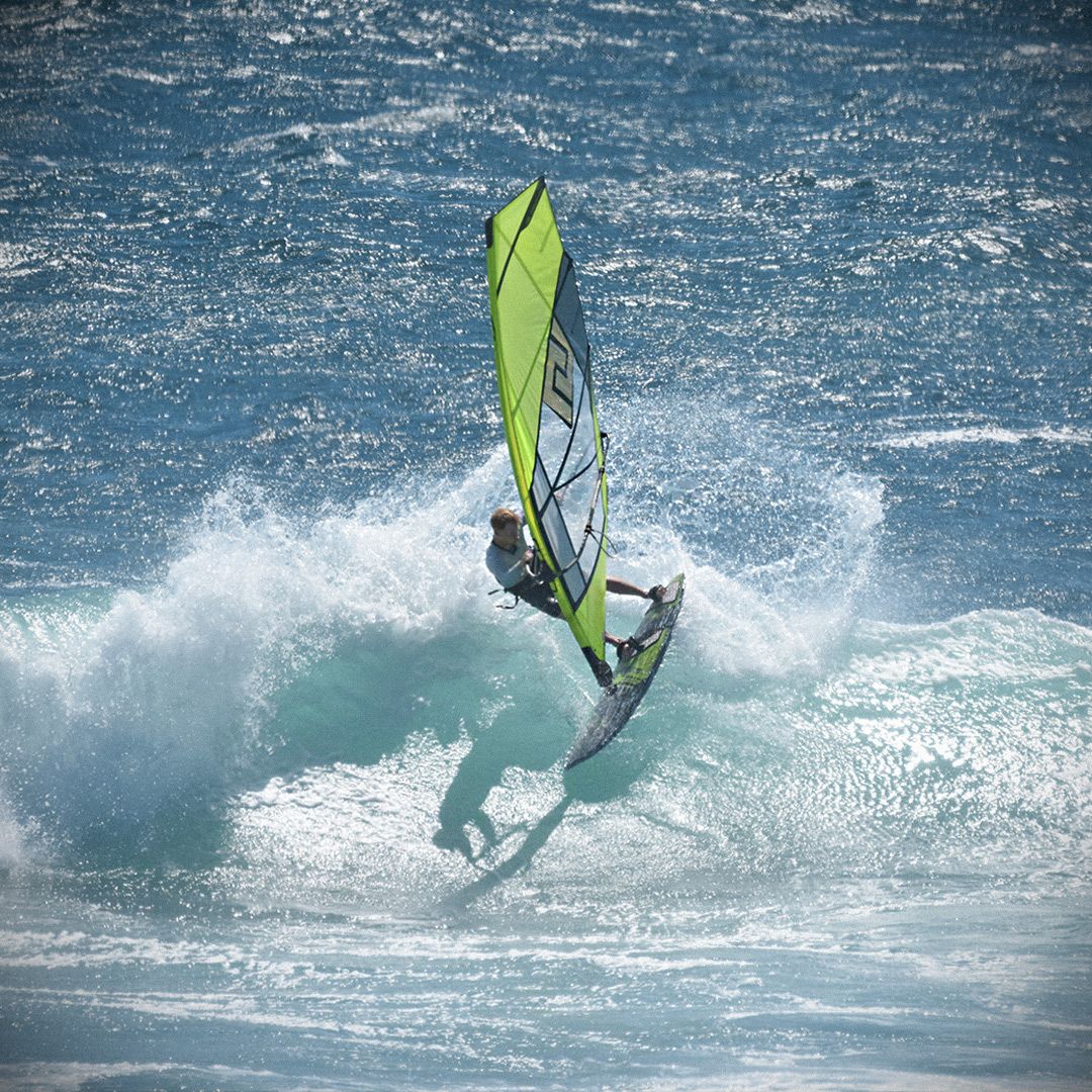 Patrik TS-Wave Windsurfboard neongelb auf Welle, Frontalansicht im Meer